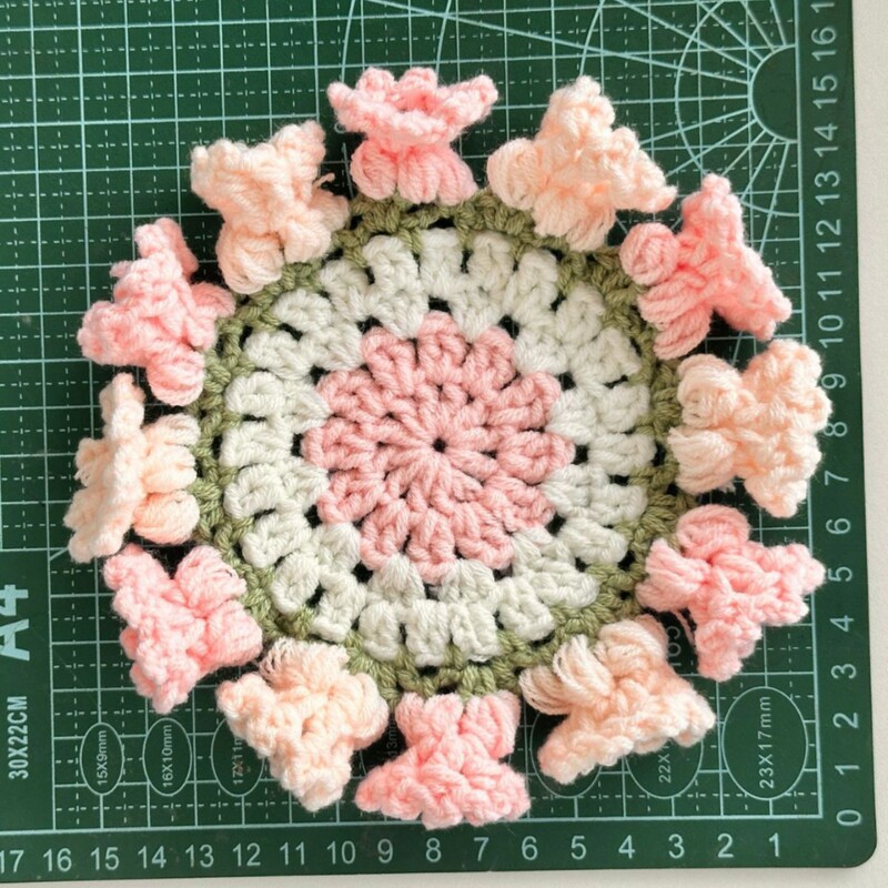 完成した手作りのバラの花束コースター、毛糸のかぎ針編みカップ、手持ちの花束、断熱手編みの花綿|undefined