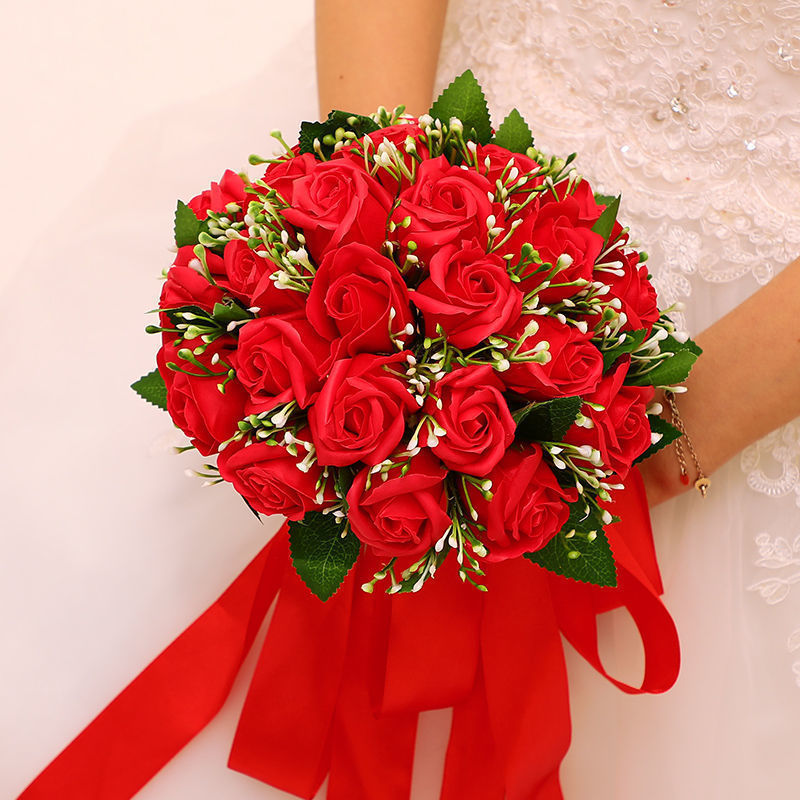 手に花を持つ新婦の韓国式結婚式の領収書のシミュレーションの花束の森系のウェディングドレスの撮影の道具の手に花をささげます。|undefined