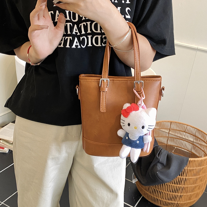 2025 nuevo bolso de cubo portátil de diseño de nicho bolso de hombro de viajero de todo fósforo de moda femenina bolso de mensajero de estilo occidental de color sólido