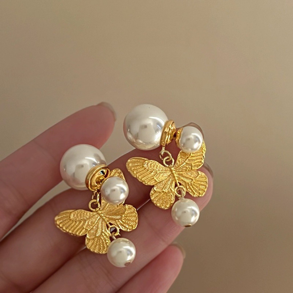 Pendientes de perlas artificiales de mariposa de aguja de plata Pendientes de todo fósforo de nicho retro femenino Pendientes de temperamento de moda Lujo ligero de alta gama