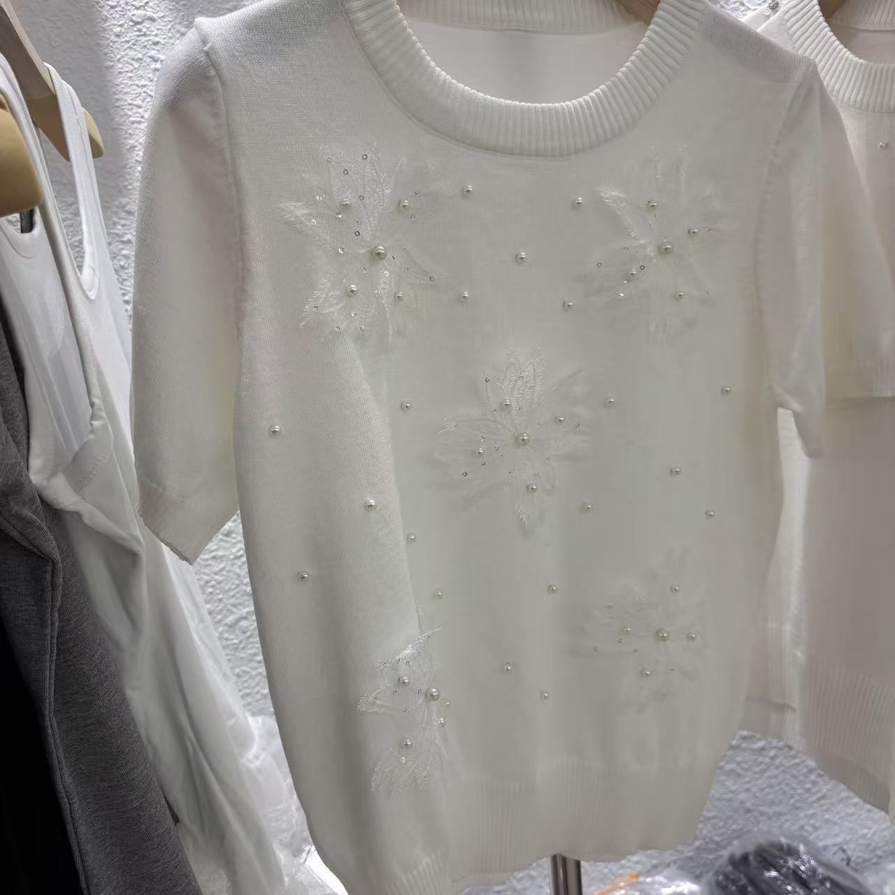 Top de punto de flores tridimensionales blancas primavera y verano para mujer nuevo diseño único y hermoso hombro recto delgado camiseta de manga corta