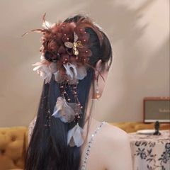 羽のビーズのフリンジは髪飾りのサメを挟んで後頭部のヘアピンを挟んで誇張しています。