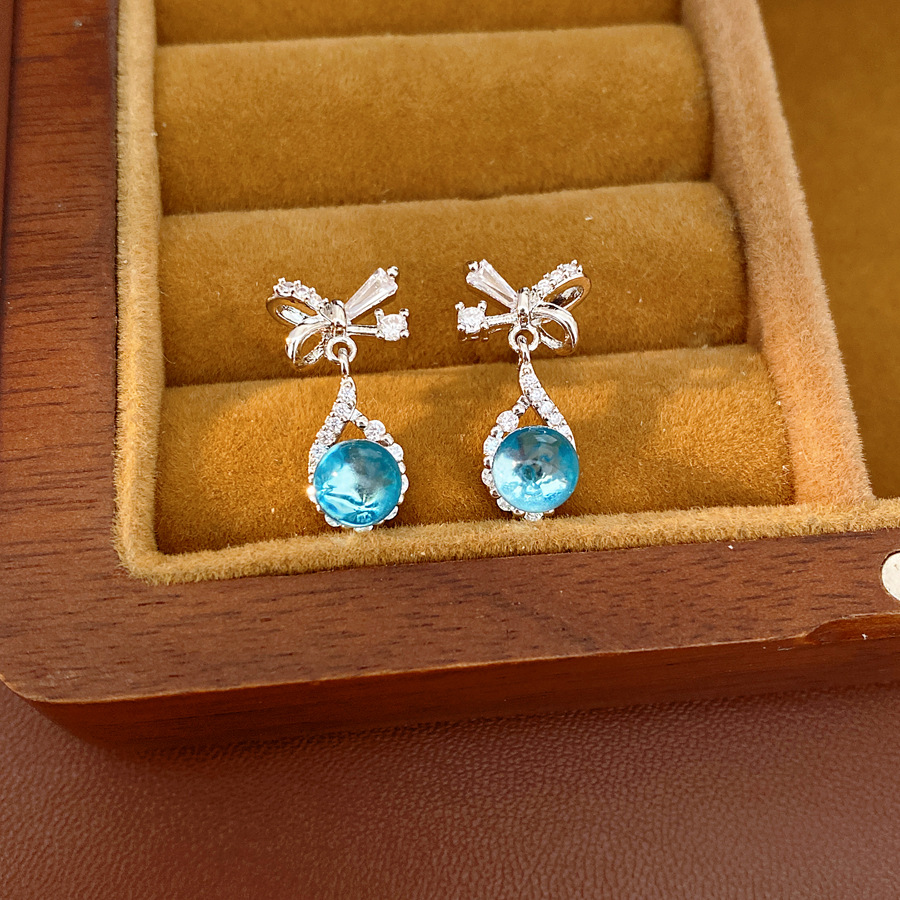 Aguja de plata zircon arco gotas de agua simple temperamento moda aretes de aretes ligeros de lujo alta sensación de aretes al por mayor