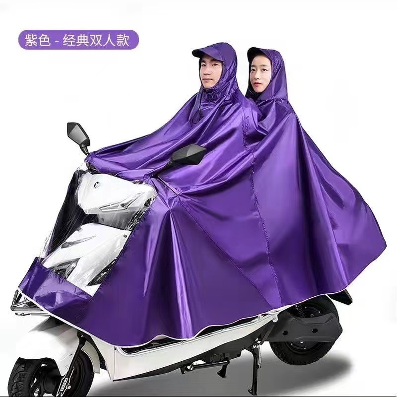 レインコート電気自動車のレインコートを大きくして、オートバイの二人のシングル男性女性が豪雨防止全身に足を隠します。|undefined