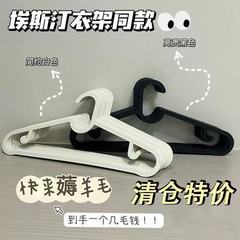 白黒のハンガーのプラスチックの滑り止めのハンガーの跡がない服はハンガーを掛けて服の店の日本式の洗濯物を展示します。