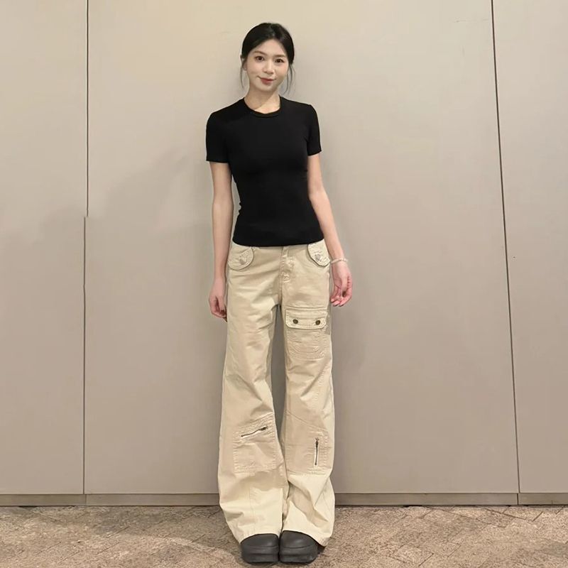 小柄な杏色の工装ジーンズの女性は腰が低くてゆったりしています。|undefined