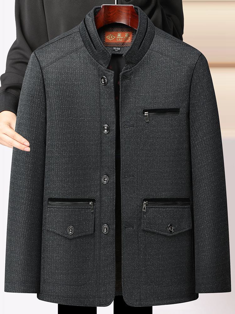 秋冬の中高年のメンズとベルベットのコートのお父さんはビジネス服の中年の男性の厚いジャケットの上着を襟を返します。