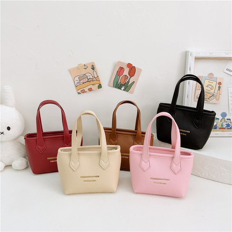 Bolsa de canasta de moda coreana para niñas simple color sólido bolso de balde de bebé 2025 nuevo bolso de comercio exterior para niños