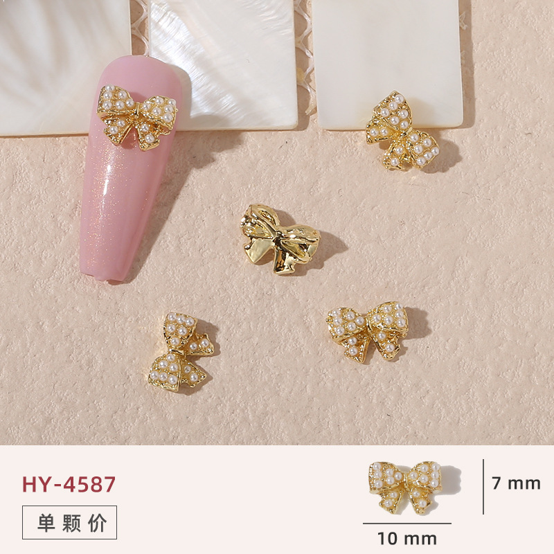 Uñas mariposa joyería nueva línea popular perla arco metal decoración de uñas pequeños accesorios de joyería al por mayor