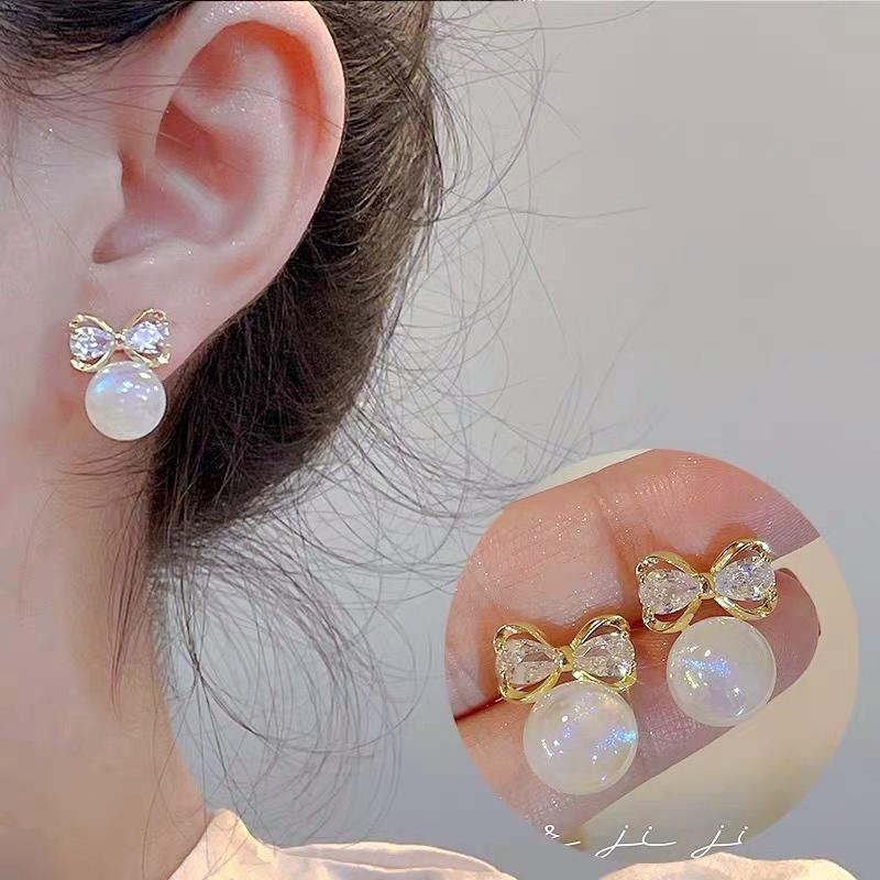 Design elegant earrings from pearl with zircon with bow