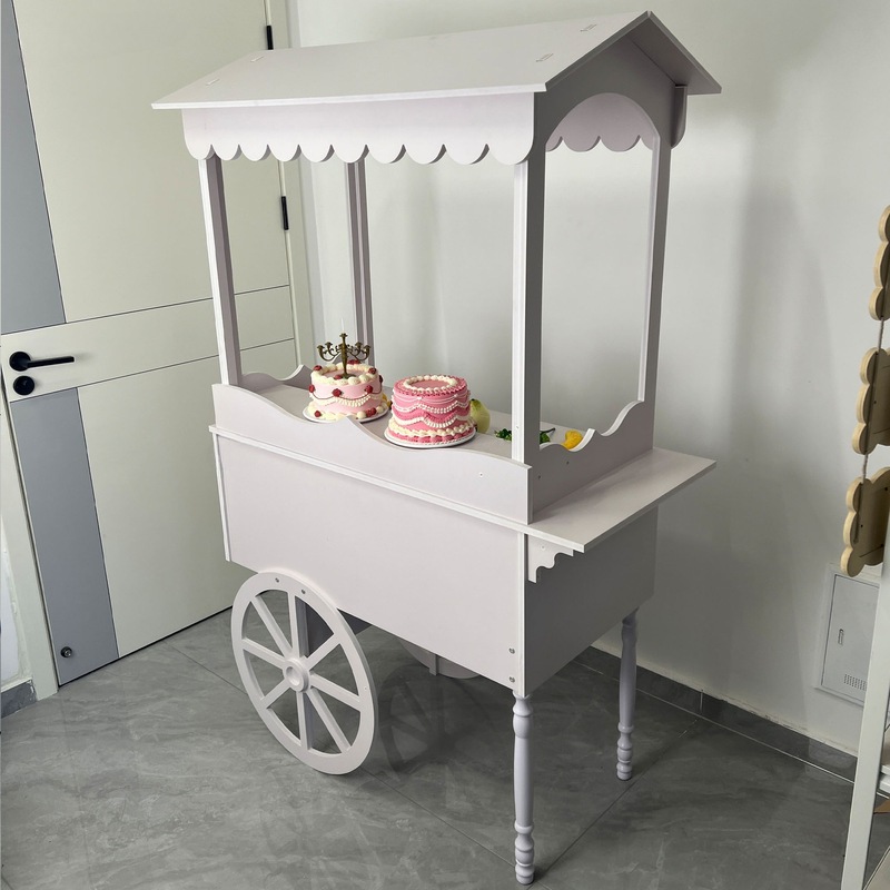 木製の車輪付き手押し車は甘い結婚式のキャンディー車の花車パーティーの市場に屋台のカートを並べます。|undefined