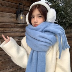 青いマフラーの女性は冬の雰囲気感を厚くして保温します。