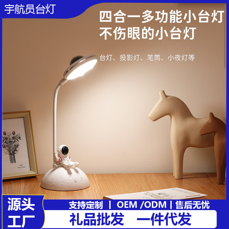 2023 nuevo escritorio creativo astronauta lámpara de mesa lámpara de proyección dos-en-uno protección para los ojos titular de la pluma lámpara de mesa de regalo al por mayor