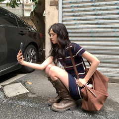フランス風の気質は青いニットの半袖のワンピースの女性を隠します。