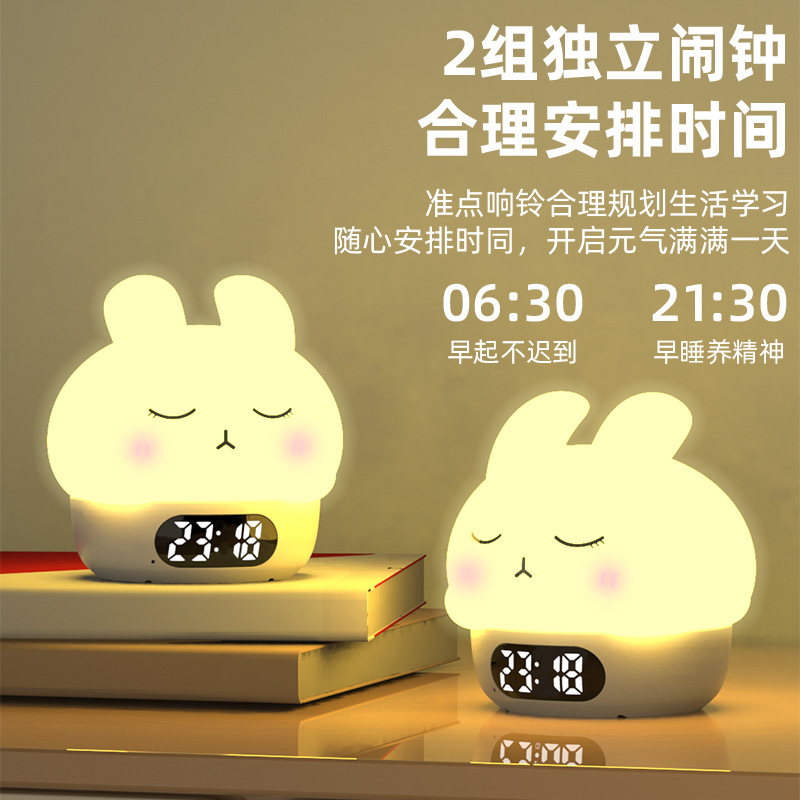 カラフルな雰囲気の恥ずかしがり屋のウサギは夜の明かりをたたいて目覚まし時計の寝室のベッドの上で乳をあげます。|undefined