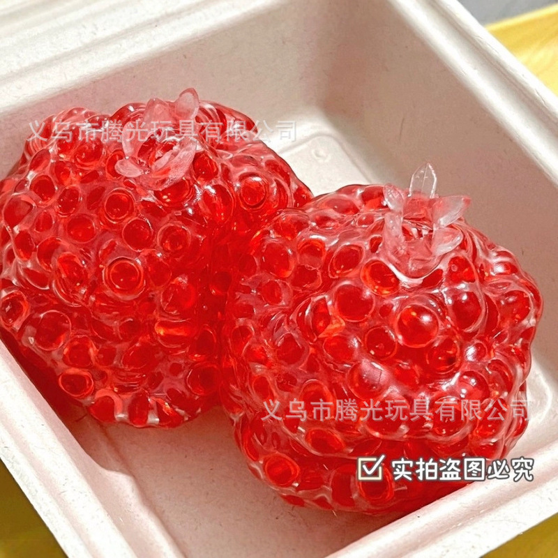 ネットの赤い爆発のココナッツの油の手はボールをつまんでゆっくりとボールをつまんで手でおもちゃの子供のプレゼントを解凍します。|undefined