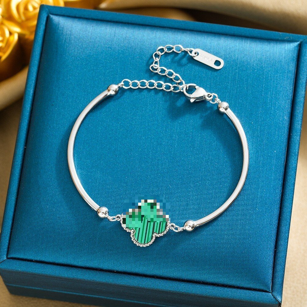 Pulsera de trébol de acero titanium vendedora caliente transfronteriza europea y americana con incrustaciones de concha pulsera colgante pulsera de diseño avanzado sin desvanecimiento al por mayor