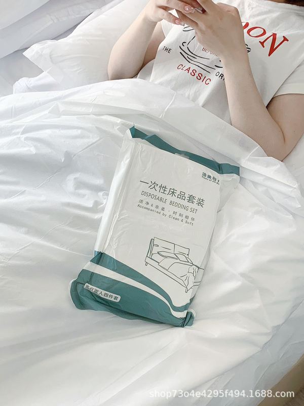 清潔で柔らかい時代の使い捨ての4セットの旅行ホテルのシーツはダブルベッドの上の用品をかぶせて汚れた寝袋をあけます。|undefined