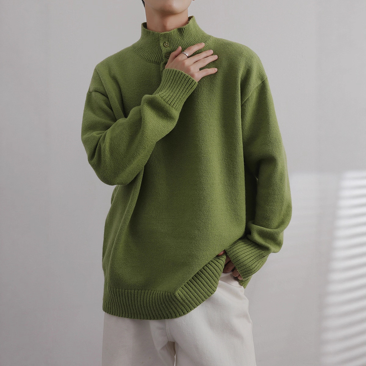 Medio cuello alto 2025, otoño y invierno, camiseta de punto de color sólido, diseño de cuello de botón, suéter de personalidad, chaqueta suelta para hombres