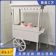 木製の車輪付き手押し車は甘い結婚式のキャンディー車の花車パーティーの市場に屋台のカートを並べます。