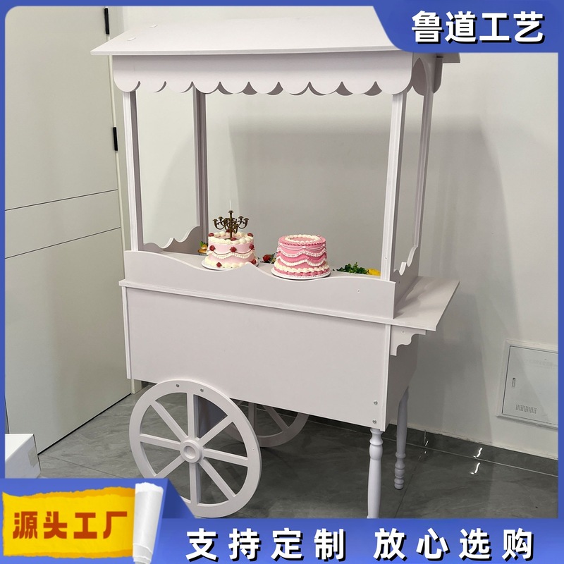 木製の車輪付き手押し車は甘い結婚式のキャンディー車の花車パーティーの市場に屋台のカートを並べます。|undefined