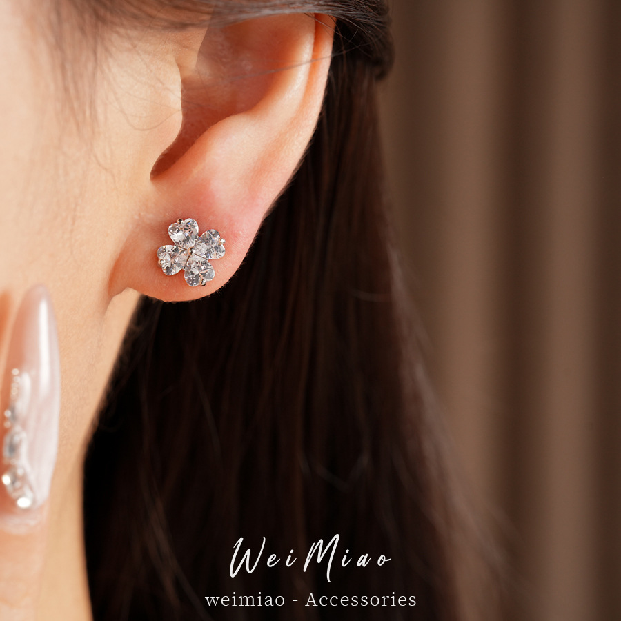 Agujas de plata zircon flores de hierba afortunada simple estilo de viaje versátil pendientes ligeros de lujo alta sensación de auriculares al por mayor