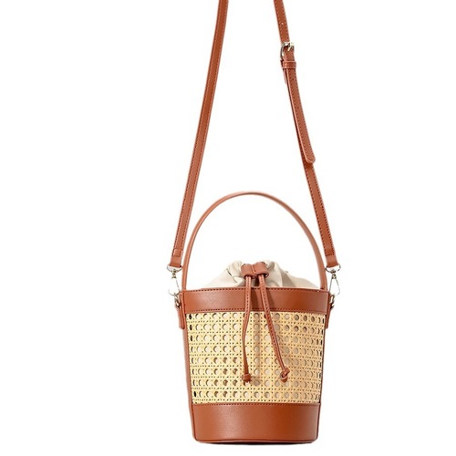 New handmade woven rattan bucket bag for women: chic hollowed-out drawstring tote perfect for beach vacations, also a unique choice as a shoulder or crossbody bag.