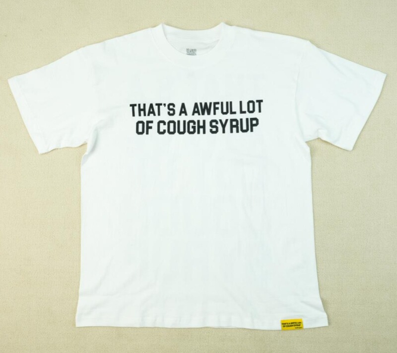それはとても多くの咳止めシロップを意味する「AWFUL LOT OF COUGH SYRUP」のシャツです。虹色の文字が入ったクロスボーダーのトレンドブランドの半袖メンズシャツです。|undefined