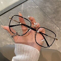 赤い本の同じタイプの黒色素の顔のメガネの女性の丸い顔はやせています。