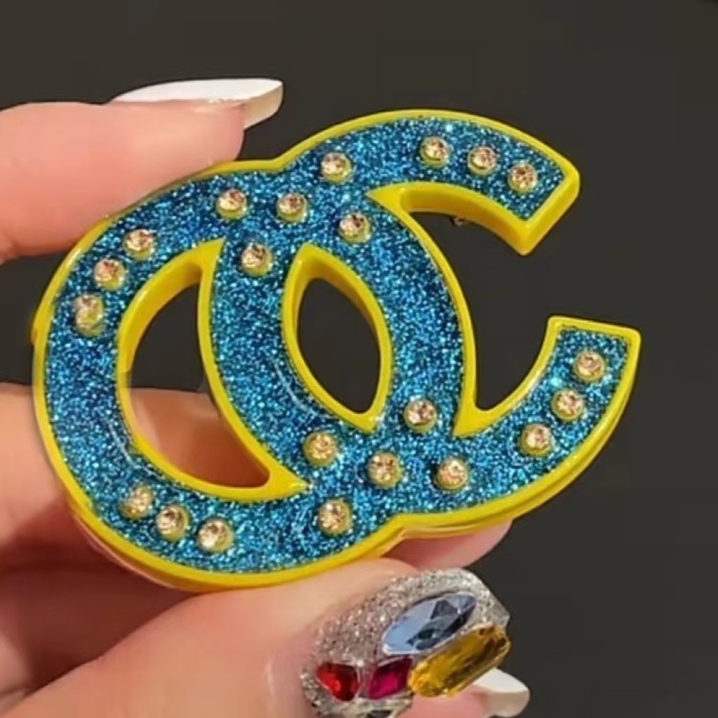 Blue brooch with letters