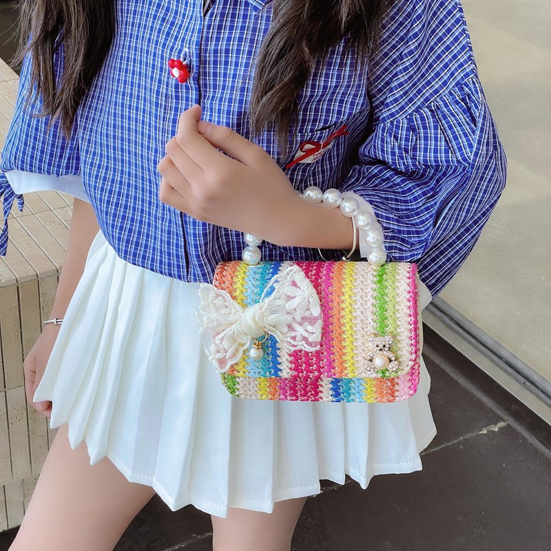 2025 verano nuevo arco de paja bolsa de perla portátil inclinada pequeña fragancia bolsa de moda para niños mochila para niñas
