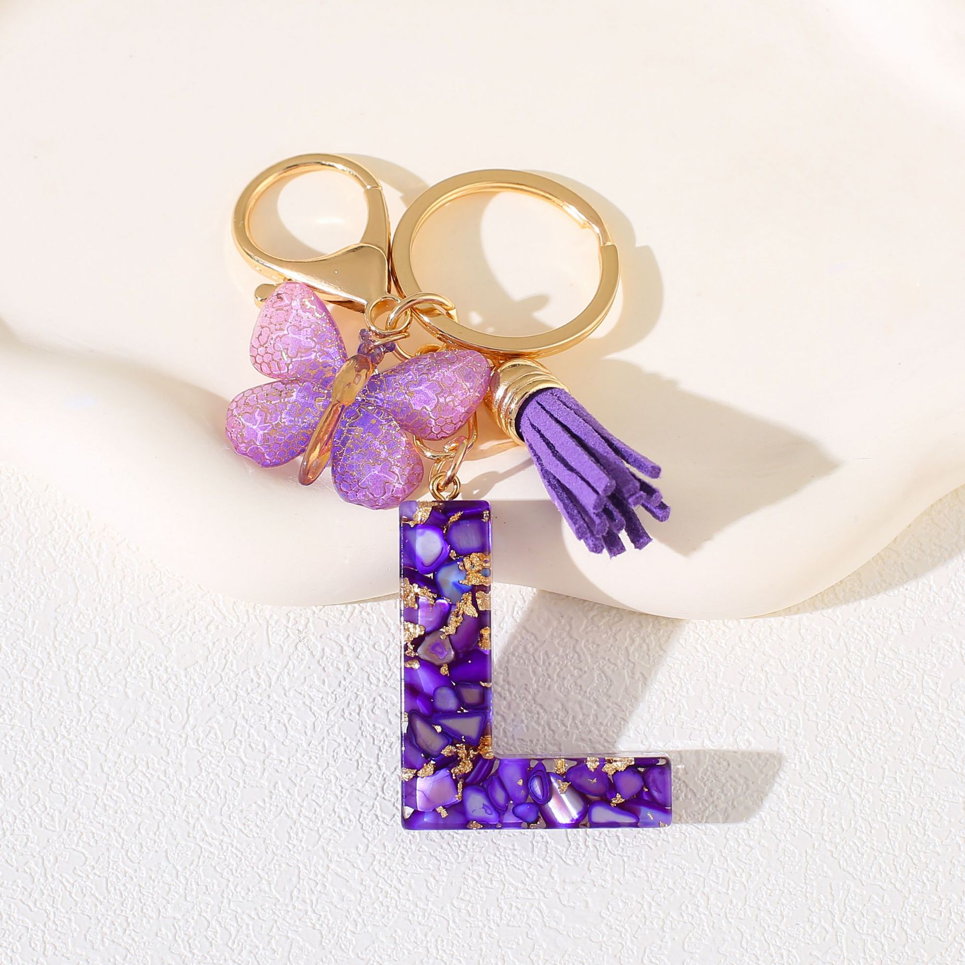 Fábrica directa de Yiwu accesorios de resina de goteo de embalaje llavero anillo de metal letras mariposa brilla colgante damas