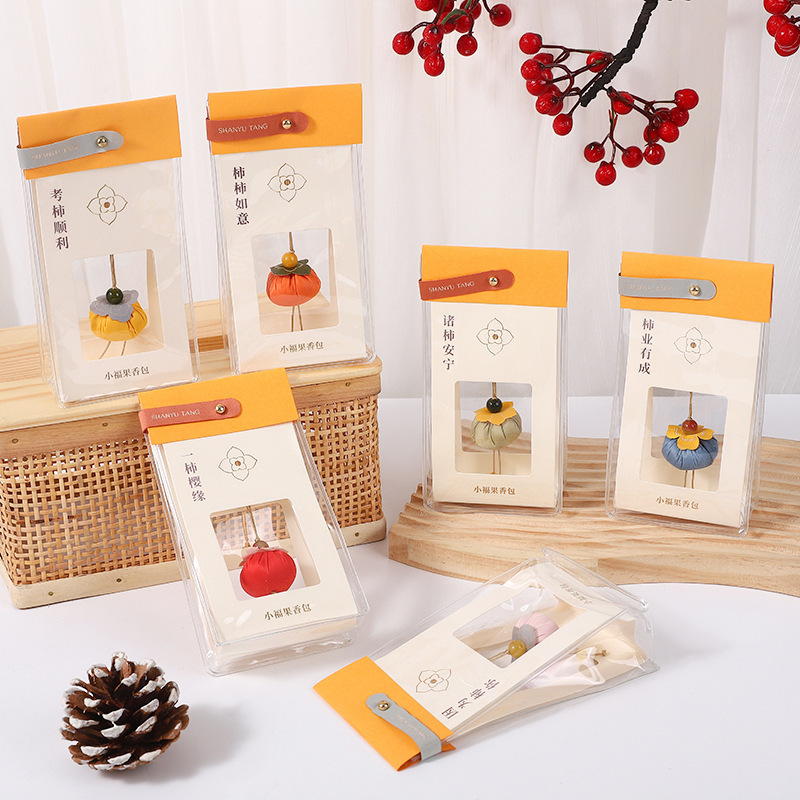 Mini persimmon-shaped sachet with sandalwood for the Dragon Boat Festival at Lingyin Scenic Area, bringing good luck and the wish for "persimmon by persimmon, all goes well" with little lucky fruits as a phone charm.