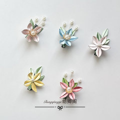 オリジナルの花を巻いて完成品の桃の花の小さい髪を挟みます。