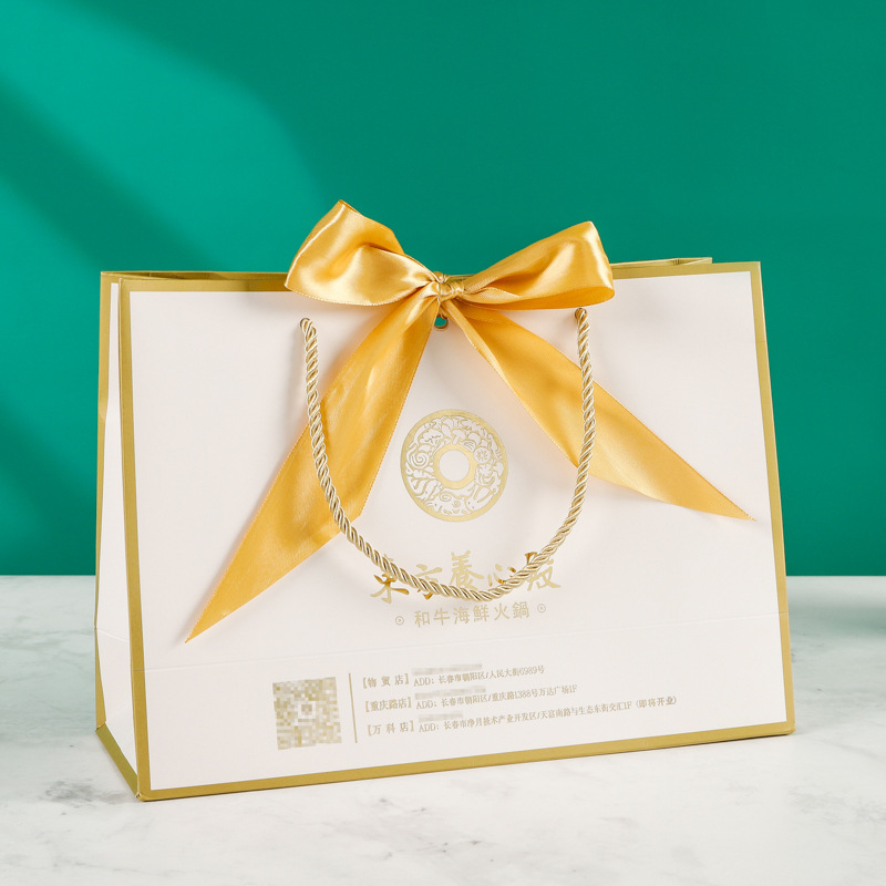 Fábrica al por mayor arco bolsa de papel portátil ropa bolsa de embalaje bolso de cartón blanco con logotipo impreso