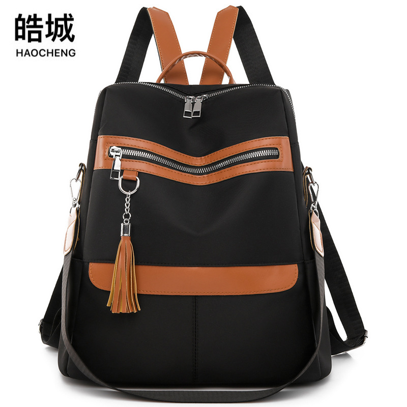 2023 nueva mochila de tela Oxford para mujer casual moda contraste color viaje urbano borla mochila de doble uso al por mayor