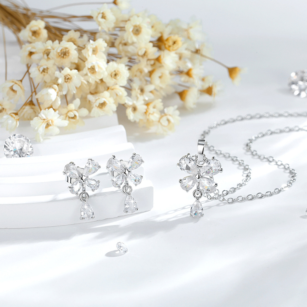 Exquisito conjunto de adornos de flores de cuatro hojas de diseño de moda transfronterizo cobre chapado en oro 14K colgante de flores de zircon aretes