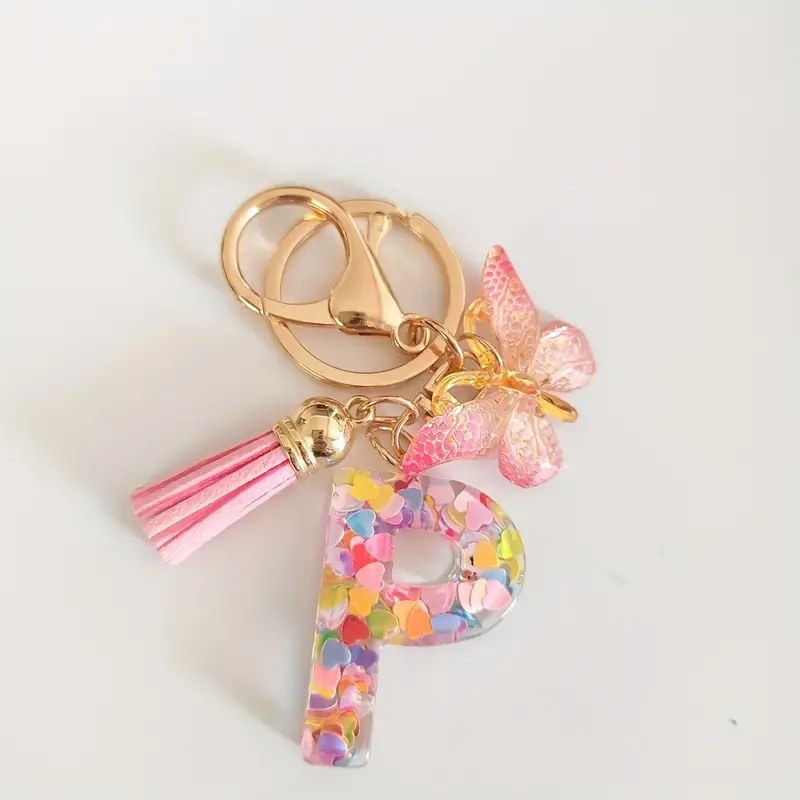 2024 transfronteriza en stock resina rosa con lentejuelas 26 letras inglesas llavero colgante mariposa borla Accesorios