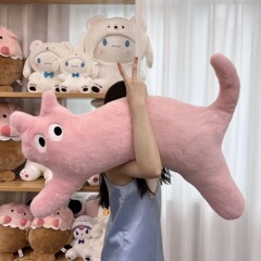 ドーパミンの長い猫が枕を抱いてベッドに寝ます。足の神器のソファーのクッションのぬいぐるみを挟みます。女の子にプレゼントします。