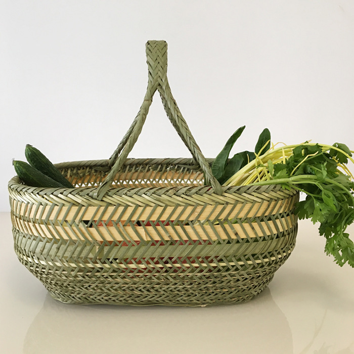 竹編みの竹かごを手に持って野菜かごを買う手作りの竹かごの果物かごの卵かごの台所収納かごの家庭用買い物かご|undefined