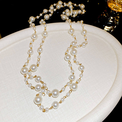 A high-end, diamond-embellished floral geometric pearl necklace with a light luxury vibe, sweater chain, French retro pendant accessory for autumn and winter.