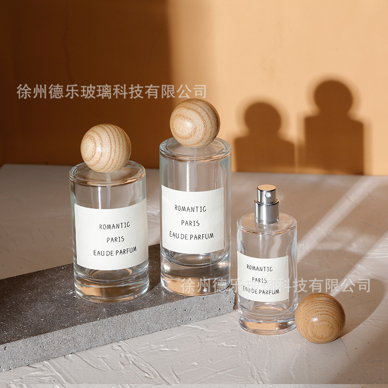 Venta al por mayor 50ml botella de perfume de vidrio cilíndrico botella de spray de perfume Cosméticos líquidos sub-botella con cubierta de bola de madera