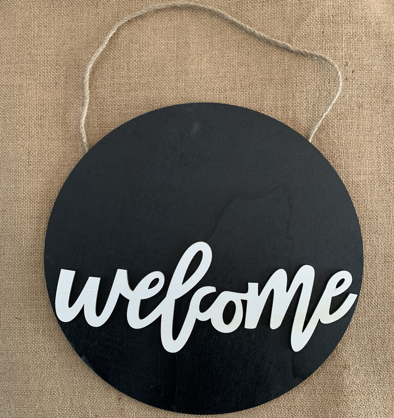 Olá estilo rural. A decoração circular inacabada da porta da frente recebe etiquetas e placas de madeira penduradas_voghion.com