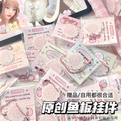 赤い本の同じ種類の魚の板の鍵はピンクの巻きのかばんの掛け物のかわいいカップルのカバンを掛けて飾ります。