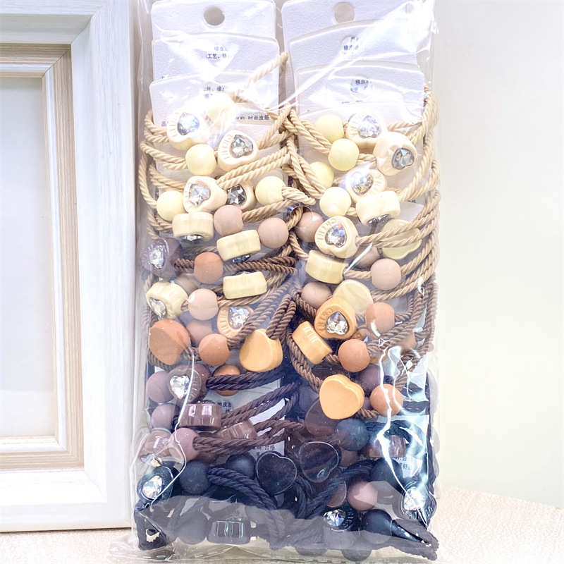 Etiqueta de estilo coreano accesorios para el cabello para niños Perla pequeña pajarita cuerda de pelo chica estudiante cabeza cuerda banda de goma dos yuanes suministro de la tienda