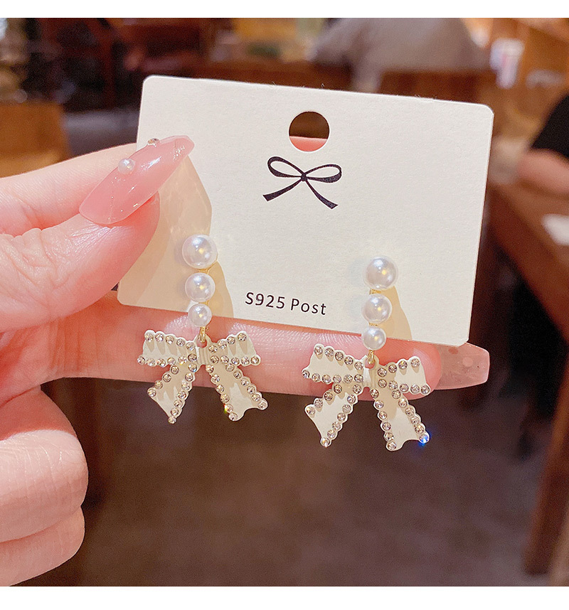 Korean Style White Bow Inlaid Pearl Alloy Earrings Wholesale display picture 4