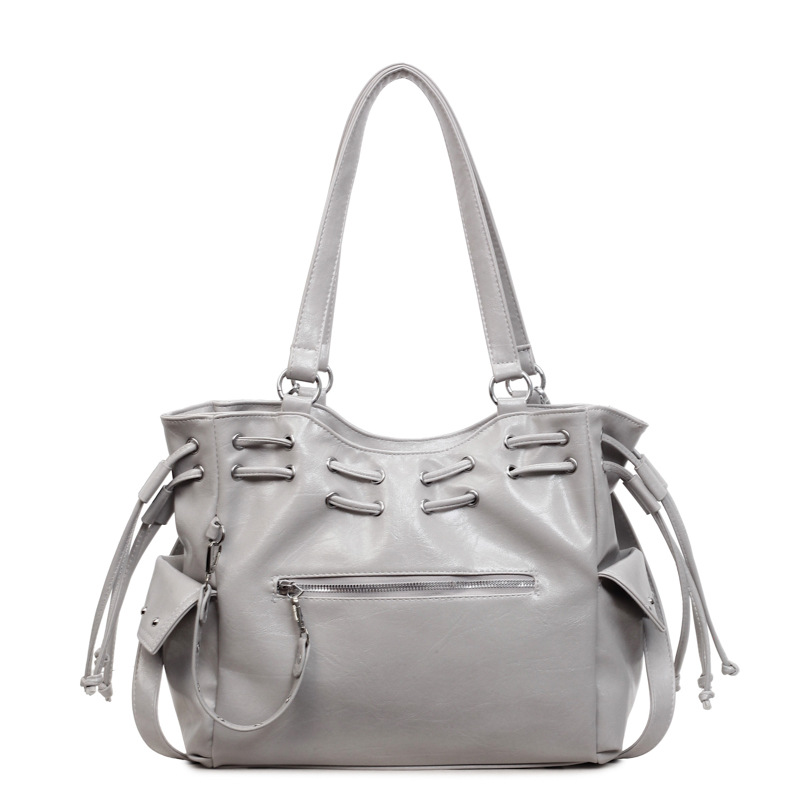 Bolsa de diseño de nicho coreano para mujeres 2026 nuevo remache transfronterizo locomotora viento de gran capacidad mochila de hombro