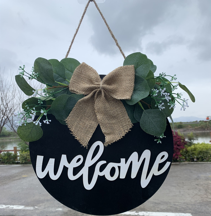 Olá estilo rural. A decoração circular inacabada da porta da frente recebe etiquetas e placas de madeira penduradas_voghion.com