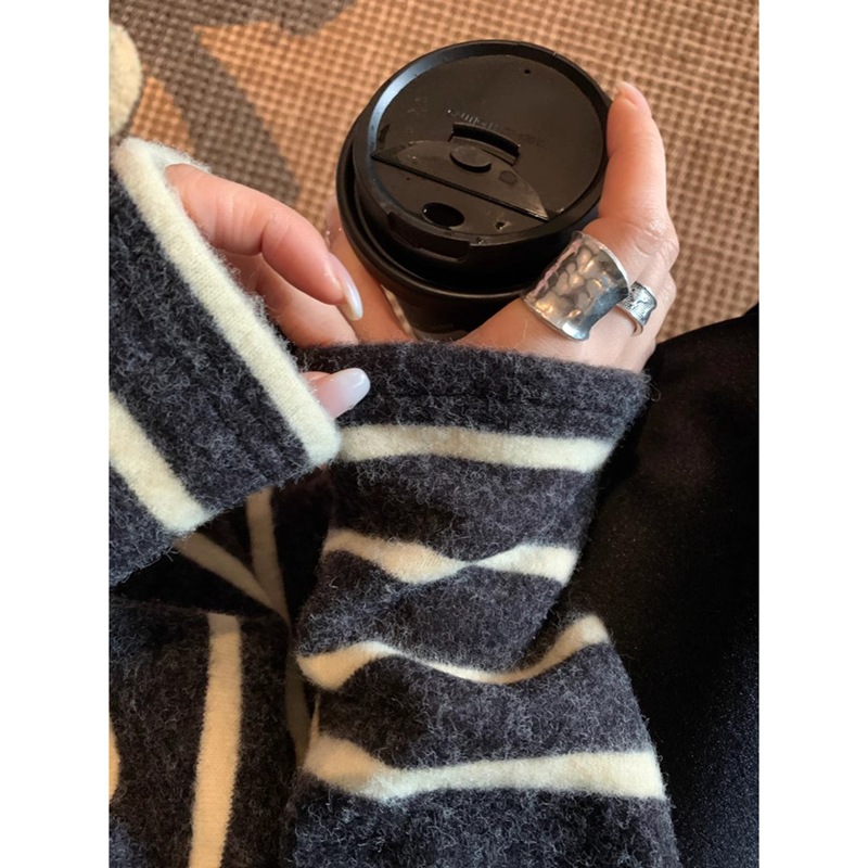 怠惰でゆったりしていて、やせている長袖のストライプのtシャツの女性の百合