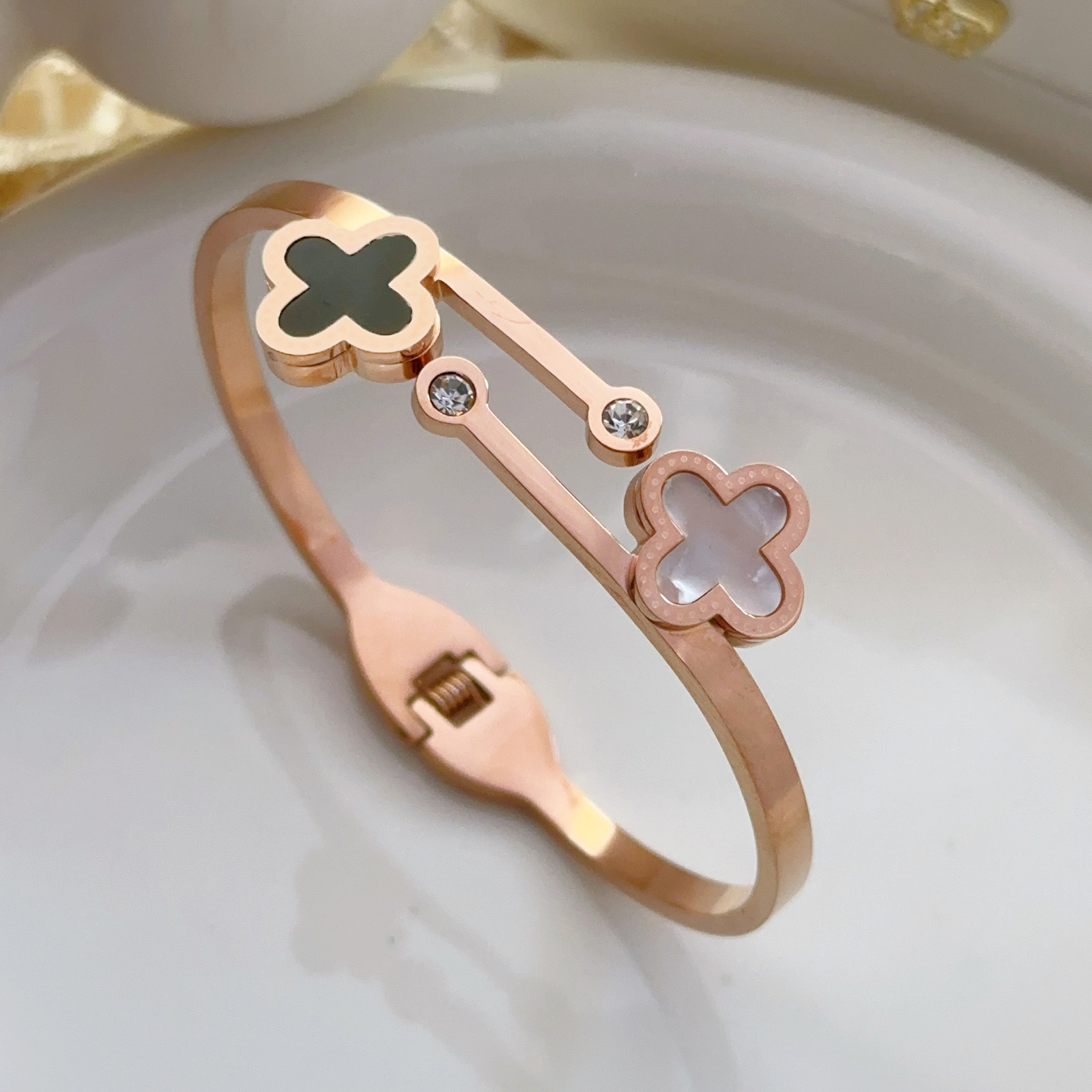 Pulsera de trébol de cuatro hojas doble en blanco y negro, pulsera abierta de concha micro dorada de acero de titanio, pulsera de todo fósforo transfronteriza femenina que no se desvanece